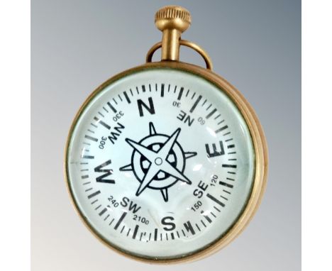 A round brass cased compass clock with large lenses either side