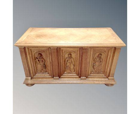 A continental oak carved panel coffer on bun feet 