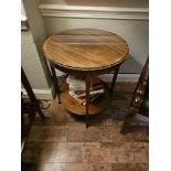 A circular side table with under tier the top with glass protective top raised on four tapering legs