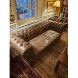 A classic English Chesterfield Kensington Sofa with curves offers timeless sophistication. This