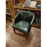 Leather Club chair with green leather upholstery and pin profile detailing sitting on carved and