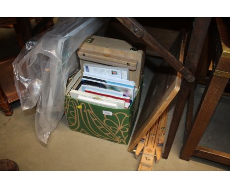 An artists traveling easel,  paint box and various art books and related items
