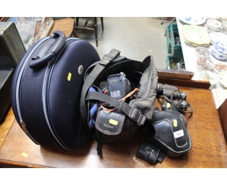 A pair of binoculars, a Minolta camera, a camcorder, carrying case etc