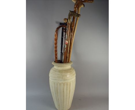 A Ceramic Moulded Vase Stick Stand Containing Seven Walking Stick Including One with Brass Horse Head