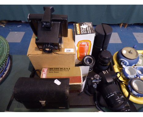 A Canon Eos 5000 Camera, Collection of Six Telescopic Lenses, Polaroid Camera, Movie Camera 