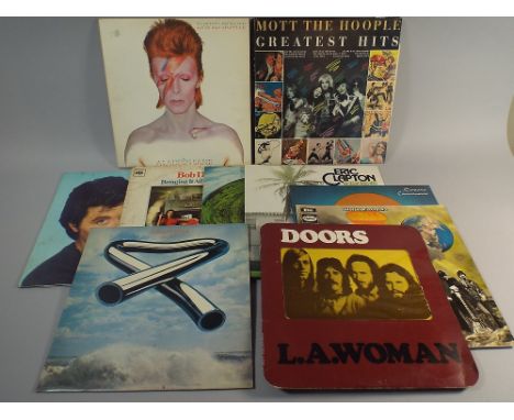 A Collection of Eleven 33 RPM Records to Include David Bowie, Mike Oldfield, Doors, Eric Clapton, Santana, Bob Dylan, Bryan F