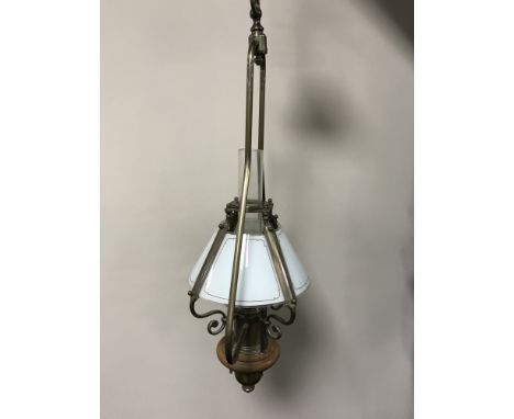 A contemporary brass light fitting in the form of a vintage oil lamp with glass shade and chimney 