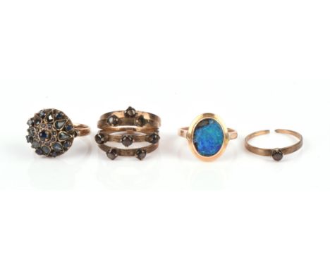 Three rings stamped "14K" consisting of a domed cluster ring with blue stones, ring size L, an opal doublet ring, ring size M