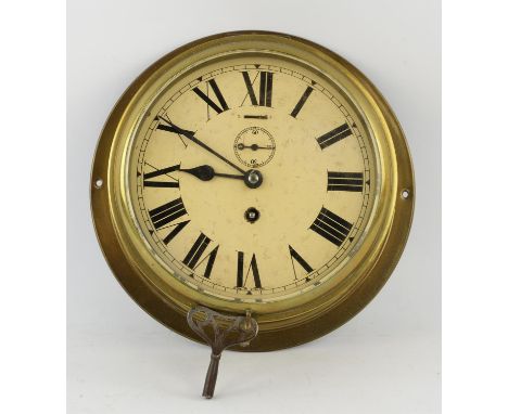 An Edwardian brass wall mounted clock, the 19cm white enamel dial with a winding aperture and seconds dial, face printed 'Mad