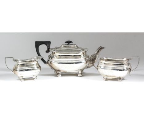 A George V silver rectangular three-piece tea service with gadroon mounts, moulded bulbous bodies, angular loop handles, on b