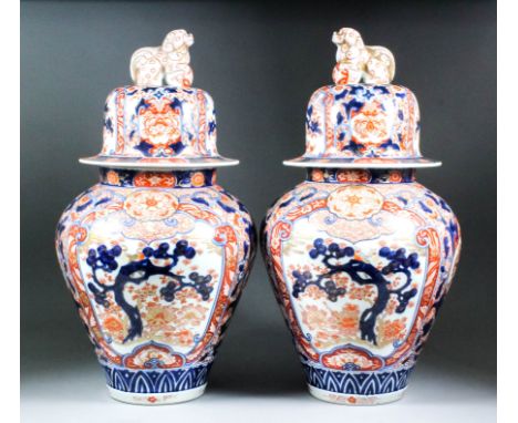 A pair of Japanese Imari porcelain baluster vases and covers with dog of Fo finials, decorated in orange, blue and gilt with 