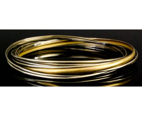 A gold and white coloured metal nine hoop bangle, 65mm diameter (gross weight 29 grammes)