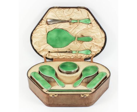 A George V lady's silver and green enamel backed nine-piece dressing table set with emerald green guilloche backs, comprising