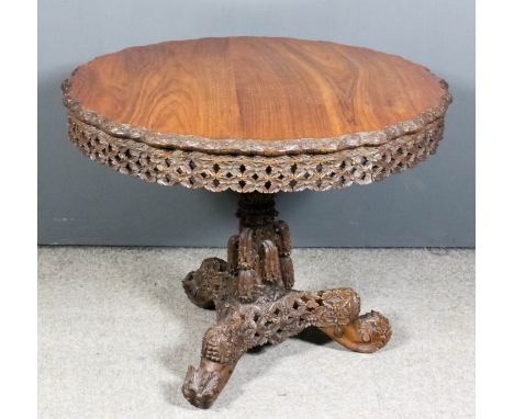 A 19th Century Anglo-Burmese rosewood circular breakfast table, the wavy rim with carved flowerhead edge moulding and with co