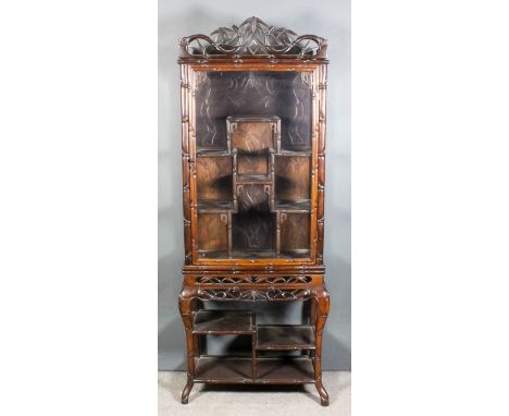 A Chinese hardwood display cabinet, the whole carved with bamboo shoots, the shaped cresting fretted and carved with scroll a