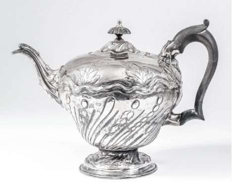 An early George III silver circular teapot of slight baluster shape, the part spiral reeded and fluted body embossed with lea