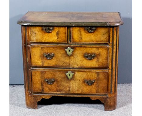 An 18th Century Continental walnut and brass mounted commode with rounded and fluted front corners, the top quarter veneered 