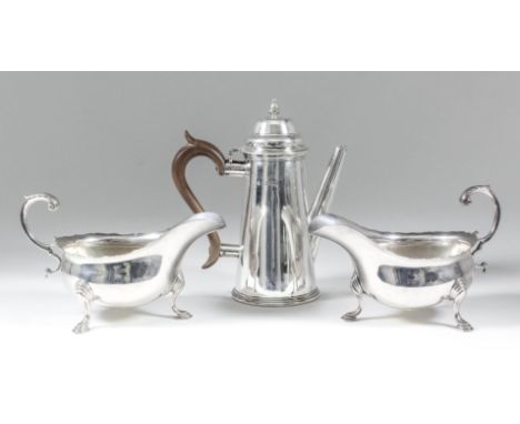 A pair of Edward VII silver oval sauce boats with shaped rims and leaf capped double C-scroll handles, on scroll and hoof pat