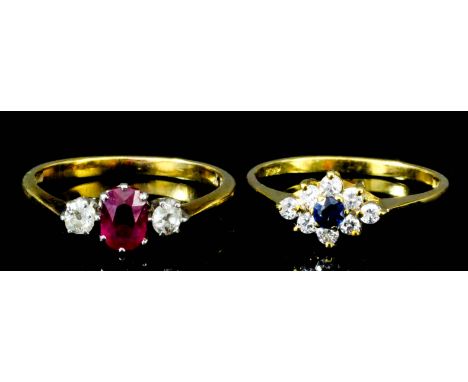 A modern 18ct gold mounted ruby and diamond three stone ring, set with central oval ruby (approximate weight .5ct) flanked by