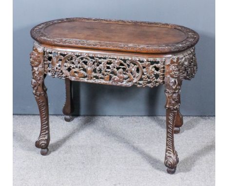 A Chinese hardwood rectangular centre table with bowed ends, the panelled top with border carved with prunus blossoms and bam