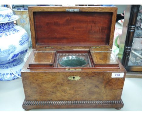 An early 19th century burr walnut tea caddy having fitted interior and bun feet