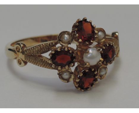 A ladies dress ring having a garnet and seed pearl open cluster on a 9ct gold loop