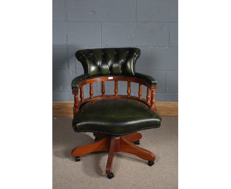 Contemporary green leather revolving desk chair, the button back above turned supports, raised on five legs with casters 