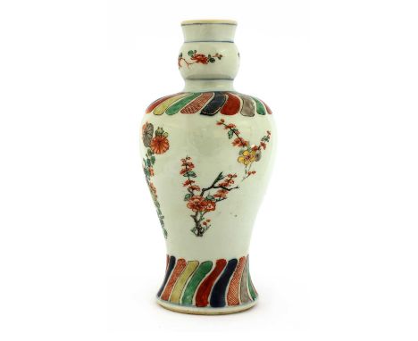 A Chinese wucai vase, Kangxi (1662-1722), of baluster form with a garlic mouth, painted with sprigs of flowers including prun