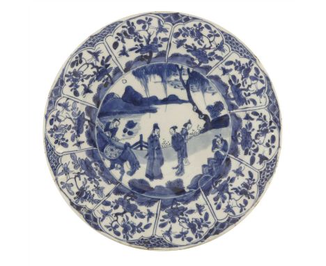 A Chinese blue and white plate, Kangxi (1662-1722), of lobed circular form, painted with figures and a horse standing under a