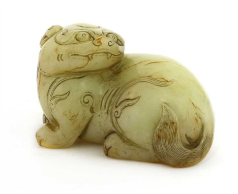 A Chinese jade carving, in the Yuan style, of a recumbent Buddhist lion, its head turned to the back, the fur engraved in det