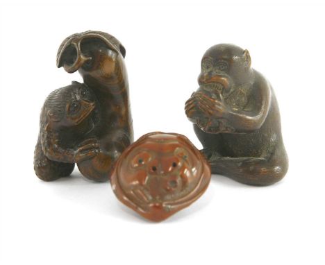 Three Japanese netsuke, Meiji period (1868-1912), one of wood in the form of a seated monkey eating a peach, signed Masamichi