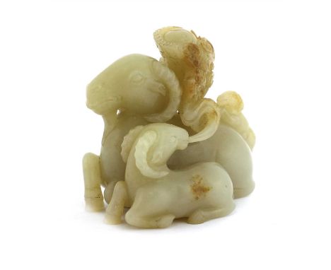 A Chinese jade carving, of three rams, one in the foreground emitting a taiji ball amongst clouds, the stone of greyish-white