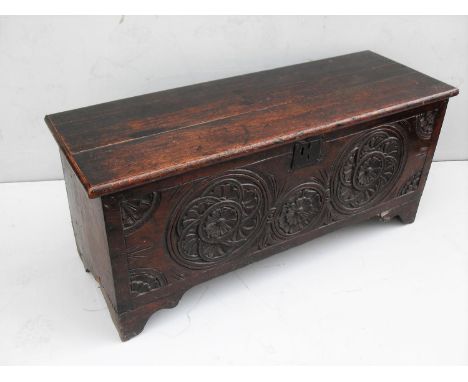 A 17th century oak coffer with Tudor Rose carving to front panel, hinged lid on bracket feet, 49 x 110 x 39cm