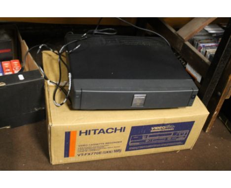 AN HITACHI VHS VIDEO CASSETE RECORDER TOGETHER WITH A GUILLOTINE