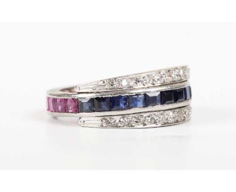 A platinum, diamond, sapphire and ruby swingover eternity ring, mounted with circular cut diamonds to the swingover sides, de