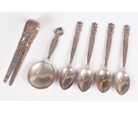 A Georg Jensen sterling Acorn pattern caddy spoon and a pair of matching sugar tongs, import mark London 1927 by Stockwell &a