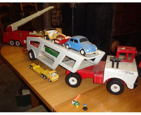 A Mighty Tonka car transporter with four cars, a Tonka fire engine and another