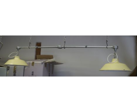 An industrial hanging light, fitted two cream metal shades, 62" long 