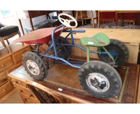 A child's 1960s pedal tractor with tip up bucket 