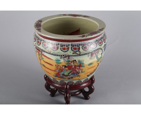 An Oriental ceramic fish bowl, on wooden stand 
