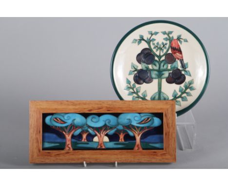 A Moorcroft ceramic panel, landscape decorated trees, 3 1/2" high x 11 3/4" wide, in wooden strip frame, and a Moorcroft dish