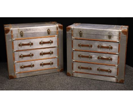 A pair of contemporary chest of drawers as a traveling trunk, hinged top above three long drawers, overlaid with foil, 80cm h