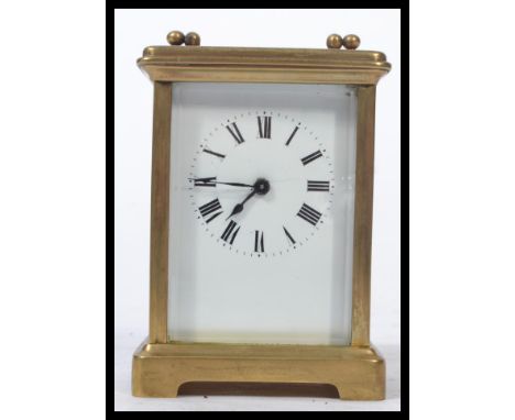 An early 20th century French gilt brass cased carriage clock having bevelled glass panels. The white enamel face having Roman