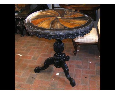 A 19th century antique Ceylonese specimen table with carved apron and tripod support showing elephants - the top diameter 75c