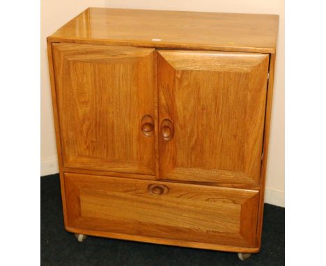 Ercol light oak television cabinet enclosed by two doors over single drawer. 85cm wide x 95cm high.