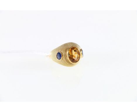 18ct yellow gold citrine and sapphire set dress ring. rub-over portrait mounted citrine accented on the shoulder points with 