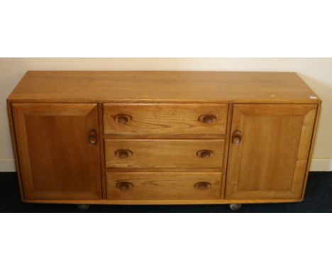 Ercol light oak sideboard fitted with three central drawers flanked by two cupboards, 156cm x 68cm x 44cm.