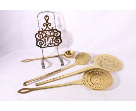 Three brass chest nut roasters, a ladle and a sliding trivet.