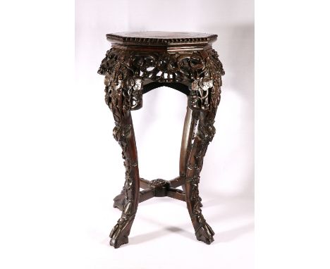 19th Century Chinese octagonal stand with inset marble top, carved and pierced apron and raised on scroll supports, 61cm.