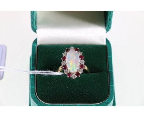 18ct yellow and white gold  opal, ruby and diamond set cluster ring. long cabochon cut Australian opal.  Portrait mounted and